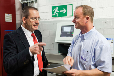 Pogovor med g. Hages, inženirjem pri družbi Kaeser, in g. Baumgarten, zaposlenim pri podjetju ZF Friedrichhafen o načrtih za kompresorsko postajo