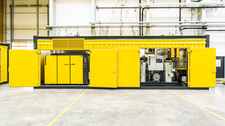 Odprt kontejner za stisnjen zrak z vidnim vijačnim kompresorjem Kaeser Kompressoren.